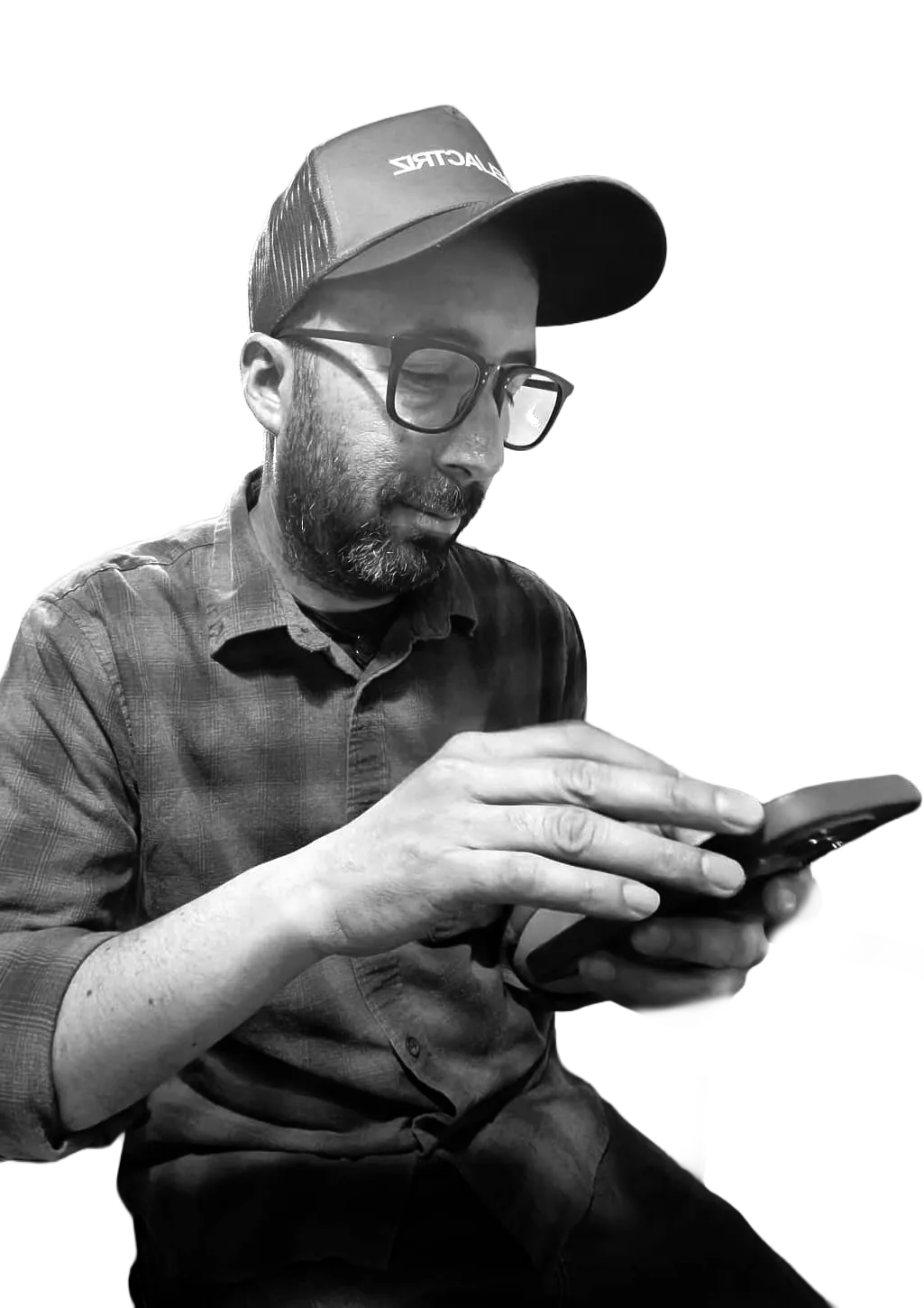 Retrato en blanco y negro de David Bravo mirando su teléfono